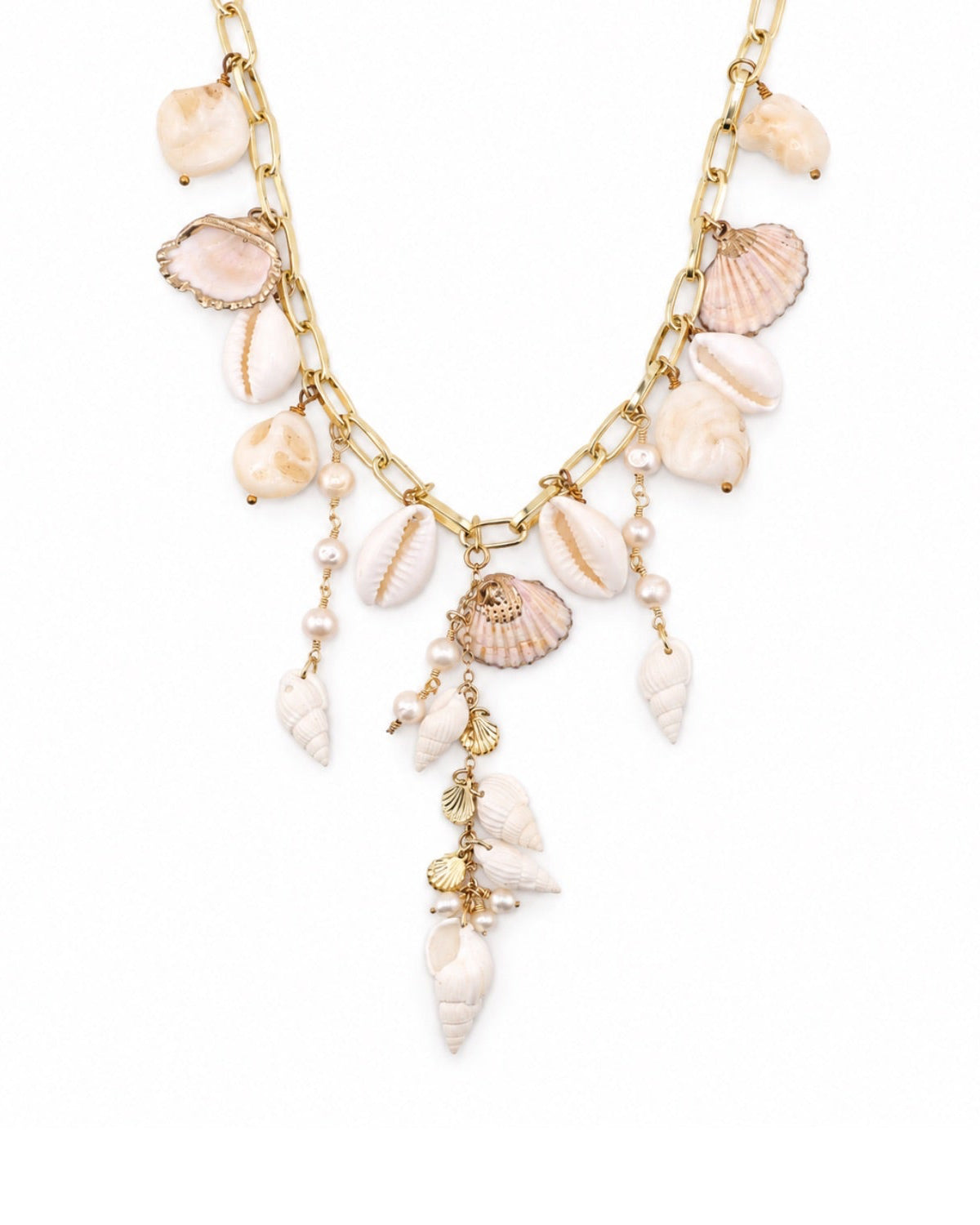 A gold-tone chain necklace adorned with various seashells and pearl-like beads in soft beige, cream, and light pink tones, displayed on a clean white background.