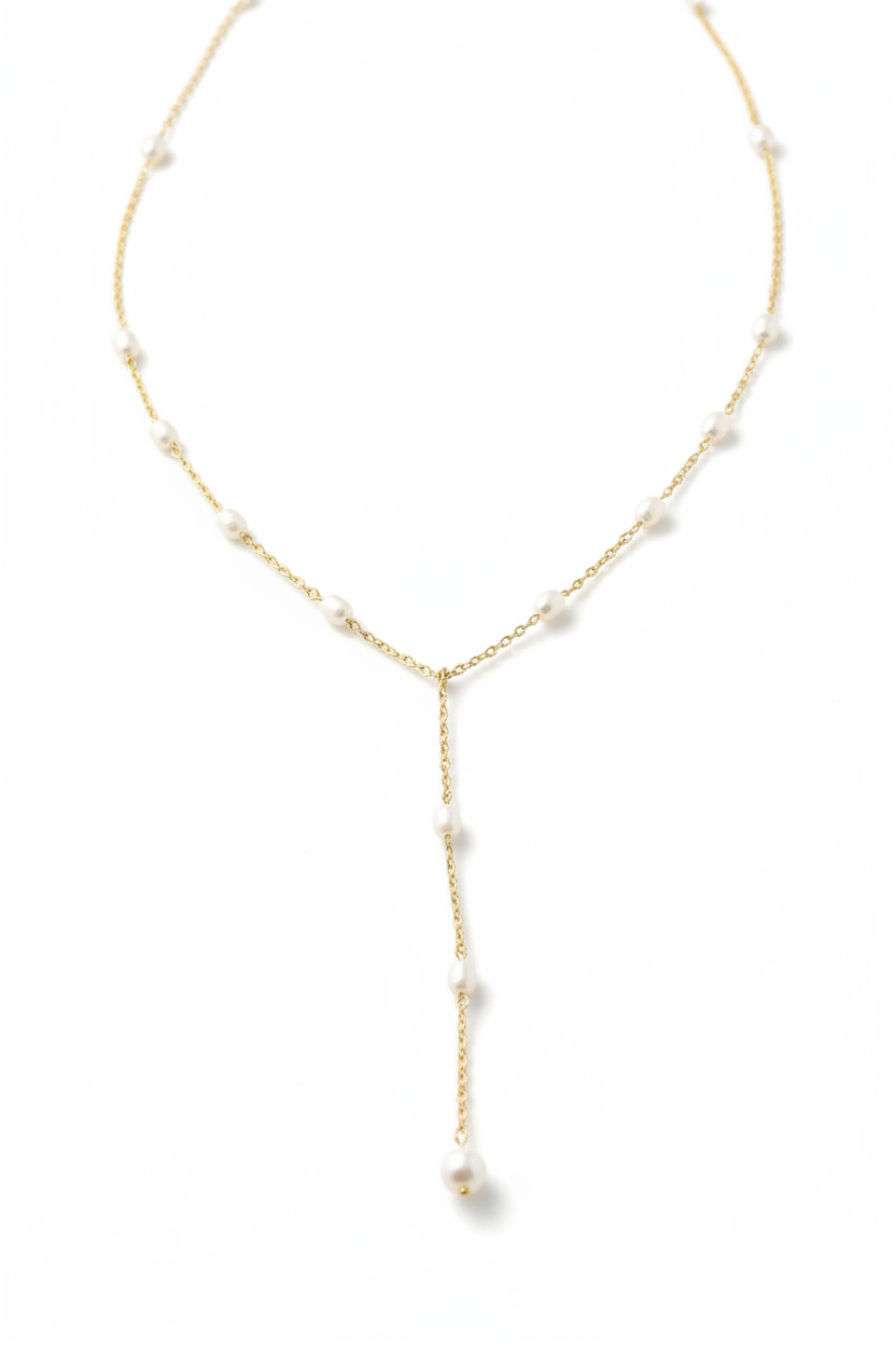 A delicate gold Y-necklace featuring small white freshwater pearls spaced along the chain and a larger teardrop pearl hanging at the center drop.