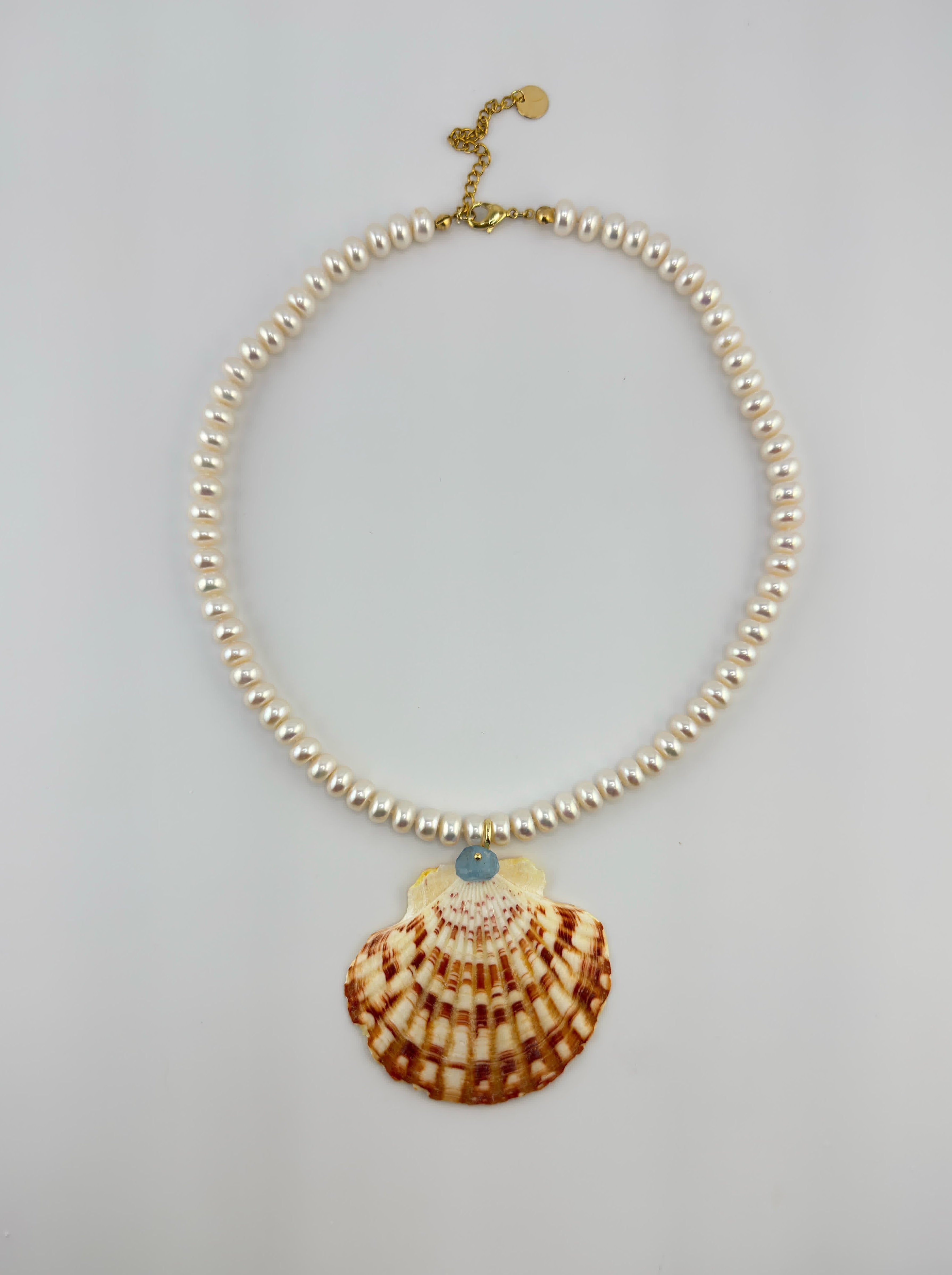 Necklace with shell pendant on a light gray background