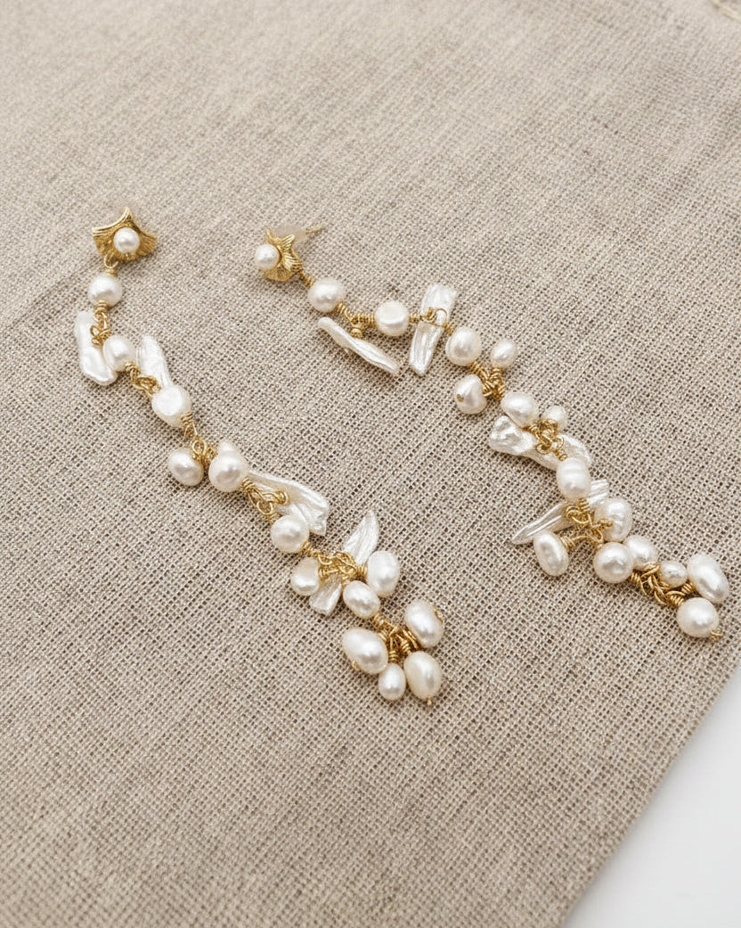 Pearl and gold bracelet on a beige fabric surface