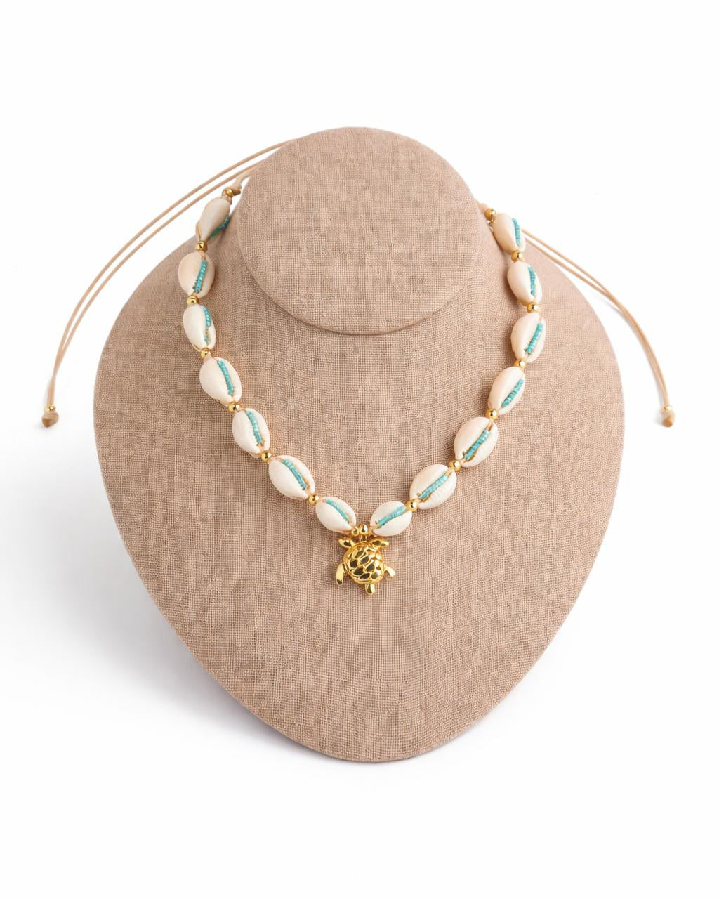 Necklace with turtle charm on a beige stand against a white background