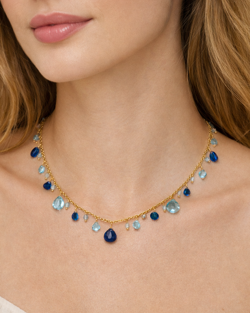 Gold necklace with blue gemstones worn by a model