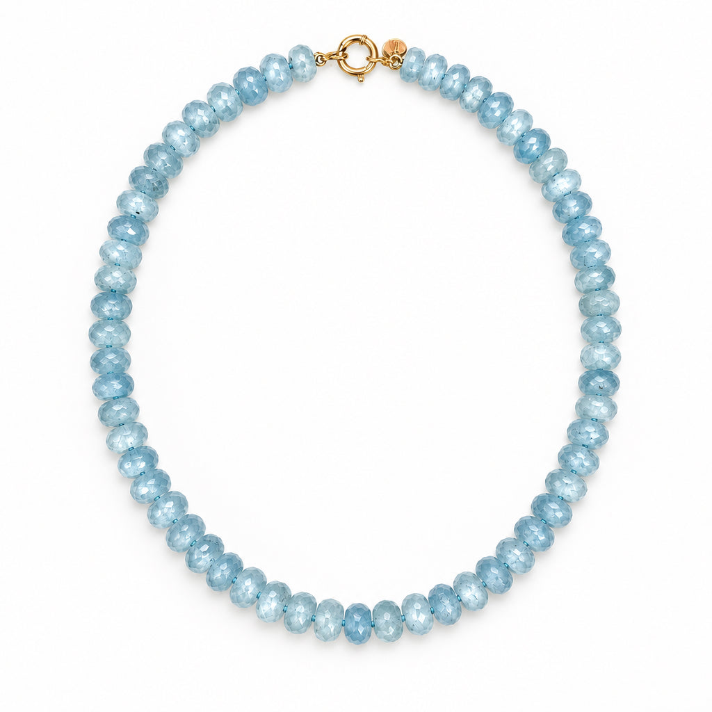 A beaded necklace made of faceted light blue gemstone beads, featuring a gold clas.Gift - Ready.