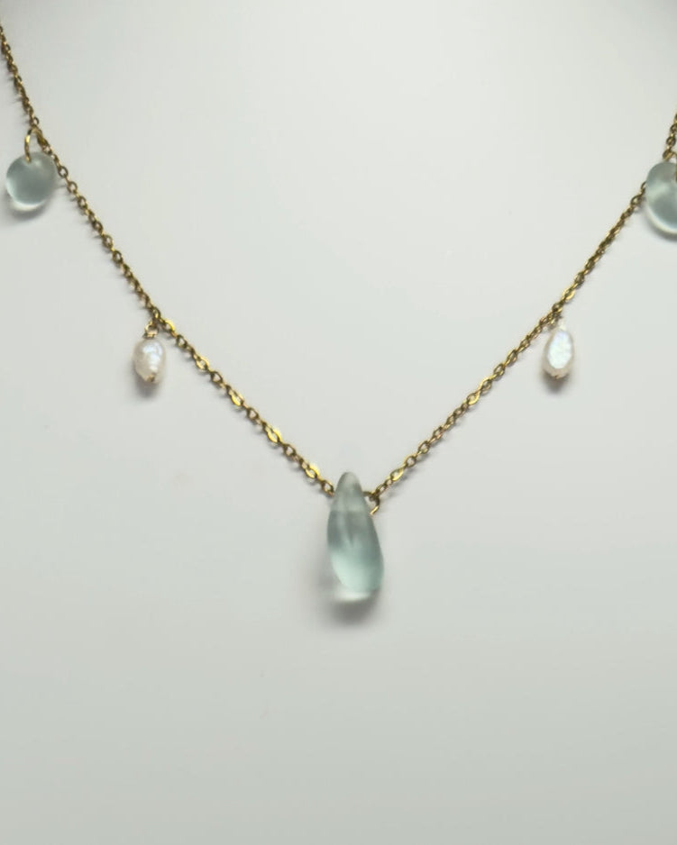 Necklace with green teardrop-shaped pendants on a mannequin bust.