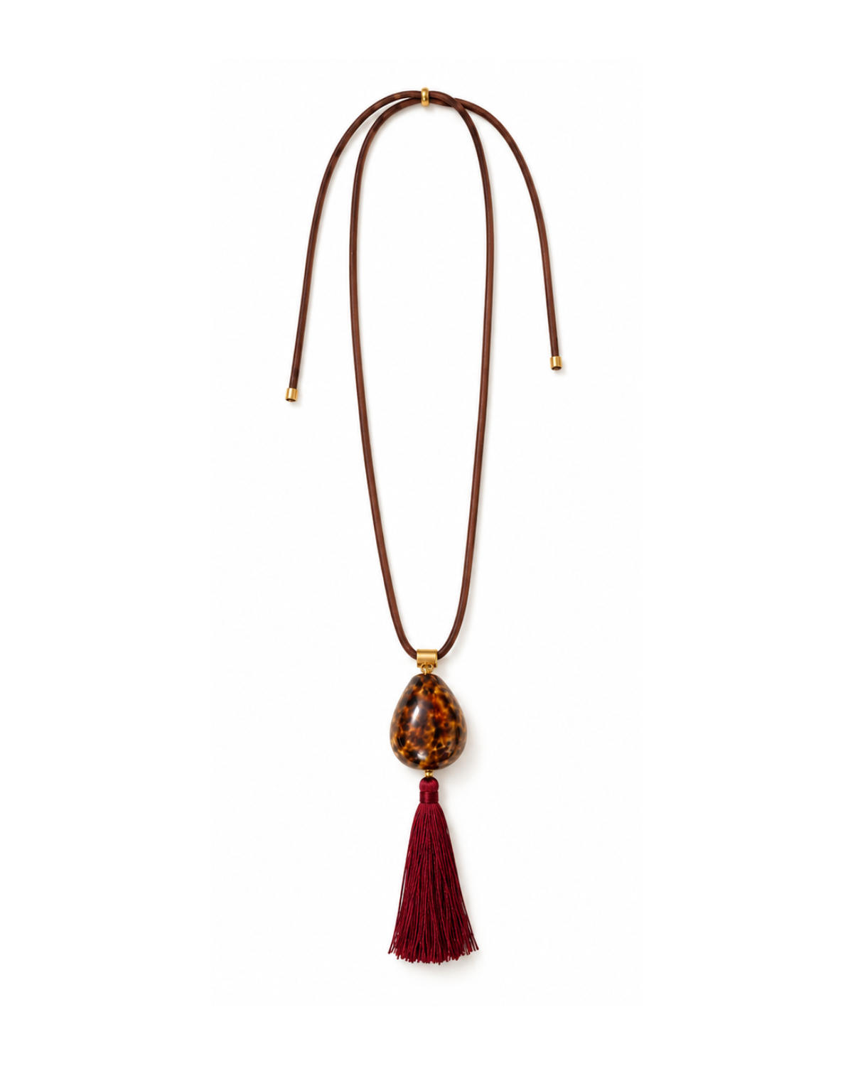 Discover the Maris Cowrie Necklace with a natural shell, adjustable brown paracord, burgundy tassel, and vintage brass details. Handmade