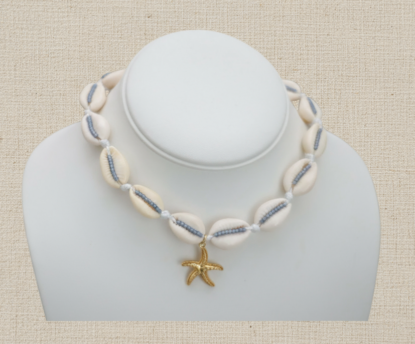 Necklace with shell beads and a starfish charm on a mannequin bust against a white background
