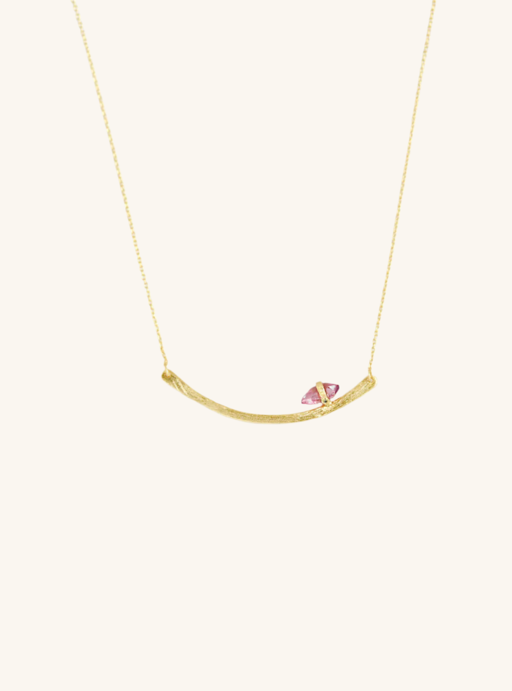 A gold-colored handmade curved bar necklace featuring a natural Tourmaline/Herkimer diamond with a single diamond accent, displayed on a white background.