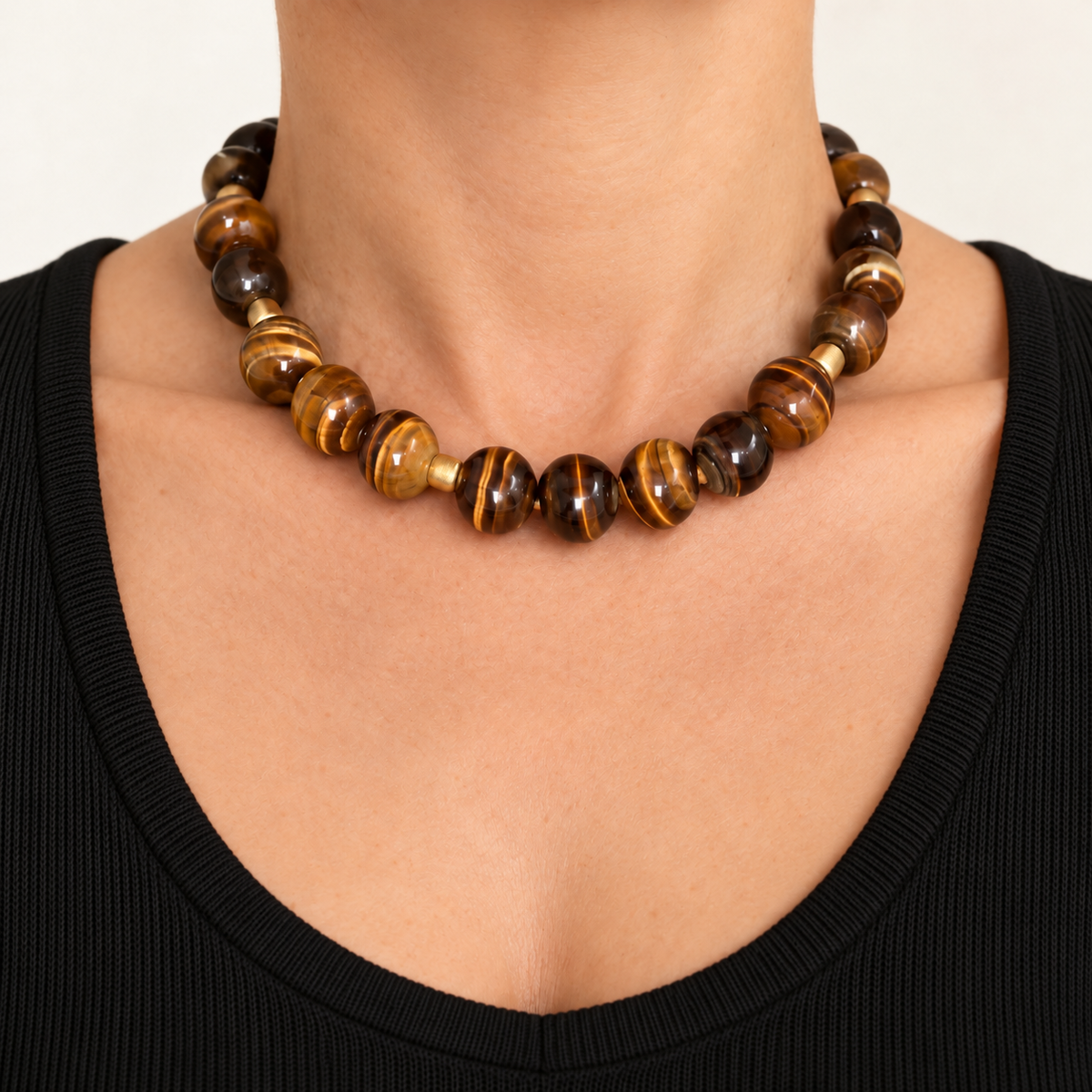 Tiger eye beaded necklace with a gold toggle claps on a white background